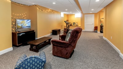 Amazing Finished Basement features a large recreation room with TV and exercise areas. Storage room at end. Sewing/craft area to the right.