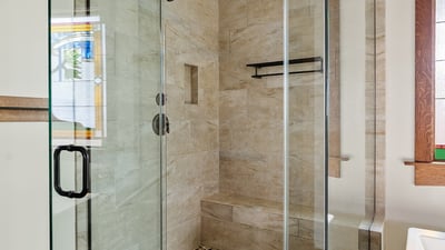 Elegant walk-in shower with detailed tilework, frameless glass, and built-in seating. A spa-like bathroom feature that reflects craftsmanship and modern comfort.