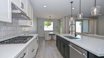 This oversized island with black paneling and quartz counters serves as the focal point, combining elegance and practicality for modern living in Peoria.