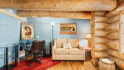 Comfortable bedroom featuring a built-in desk area and seating, offering flexibility for guests, hobbies, or a home office within a rustic setting.