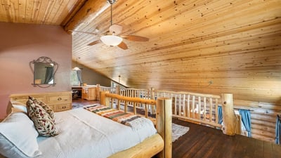 Owner s bedroom offering space for seating, natural light, and rustic finishes that enhance comfort and livability.