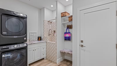 Combined laundry and mudroom features a tiled pet shower, storage, and garage access for everyday ease.