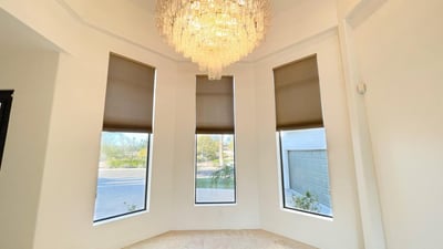 Graceful dining area framed by tall windows and a sparkling chandelier, creating a luxurious setting for intimate gatherings.