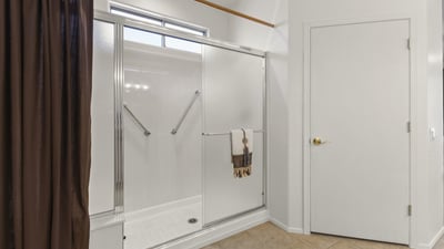 Enjoy this clean, updated bathroom featuring a large glass shower, neutral finishes, and plenty of natural light.