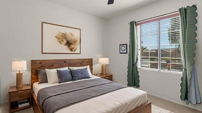A cozy and bright guest bedroom offering plush carpeting, ceiling fan, and restful ambiance for visitors or everyday living.