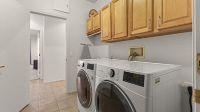 Efficient laundry room featuring full-size LG washer and dryer, cabinetry for storage, and bright, easy-care finishes.