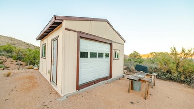 This durable workshop provides ample space for projects, tools, and storage. Surrounded by desert landscape and mountain horizons, it enhances the property s rural functionality.