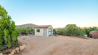 A functional workshop sits against a backdrop of scenic mountains, providing useful storage or project space with unmatched Hackberry views.