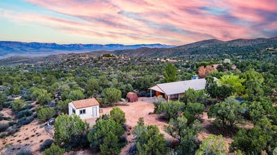 A higher vantage point shows the property s wraparound vegetation, hillside placement, and scenic setting. The peaceful Hackberry backdrop enhances the property s rural charm and quiet lifestyle appeal.
