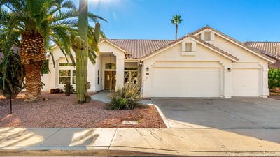 Attractive Scottsdale home exterior surrounded by mature palm trees and native desert landscaping. The well-maintained fa ade, tile roof, and inviting front walkway highlight the home's updated design and strong curb appeal.