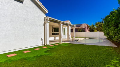 Large Scottsdale backyard combining a manicured lawn with a private pool and covered patio. The outdoor space offers room for entertaining, recreation, and peaceful relaxation.