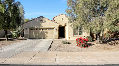 Clean front fa ade with attached two-car garage and mature desert landscaping, offering everyday convenience and curb appeal.