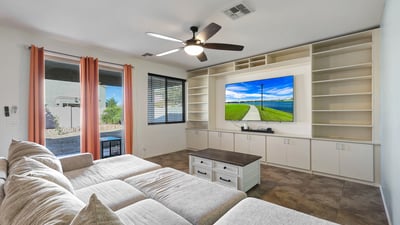 Open great room with built-in cabinetry, tile floors, and natural light, connecting indoor comfort with outdoor access.