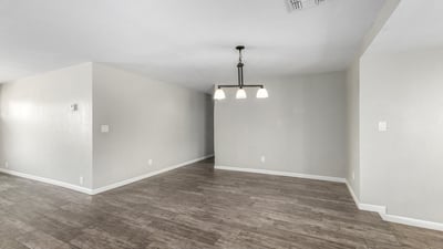 Clean and bright dining space with updated pendant lighting, neutral paint, and durable wood-look tile flooring an ideal setting for entertaining in this Phoenix home for sale.