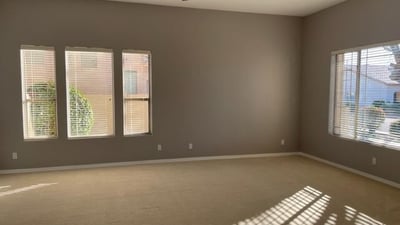 Generous living space with ceiling fan, carpeted comfort, and flexible layout options for modern living and entertaining.