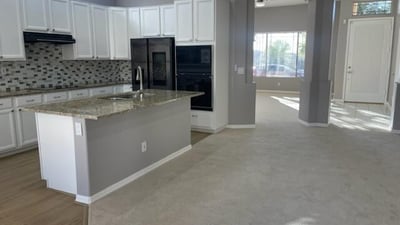Stylish kitchen featuring granite countertops, upgraded appliances, white cabinetry, and an open layout ideal for daily use and entertaining.