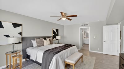 Calm and inviting primary suite with neutral tones, ceiling fan, and a spacious layout ideal for relaxation.