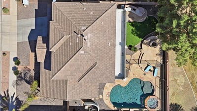Direct overhead aerial showcasing the backyard design with pool, spa, patio seating areas, and landscaped yard perfect for outdoor entertaining in Queen Creek.
