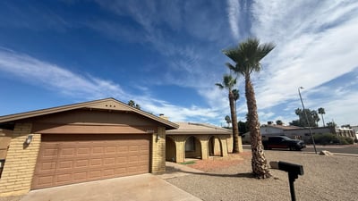 Front entry and garage view highlighting the arched porch architecture and spacious driveway. This Glendale property features a practical layout with attractive curb appeal.