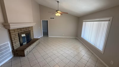 Large living area with vaulted ceilings, tile floors, and a fireplace feature wall. The open design creates a comfortable setting for entertaining in this Glendale property.