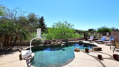 Backyard pool with unobstructed golf course views and desert landscaping. This Phoenix home offers privacy, open space, and resort-style outdoor features.