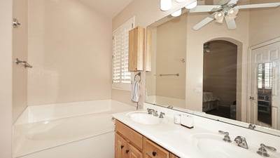 Primary bathroom with dual sinks, large mirror, and bright lighting. This Phoenix home offers convenience and comfort in a well-designed layout.