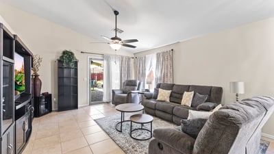 Spacious family room with sliding door leading to the backyard, ceiling fan, and open design for seamless indoor-outdoor living.