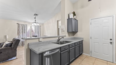 Functional kitchen featuring ample cabinetry, generous counter space, and included appliances, all open to the main living areas