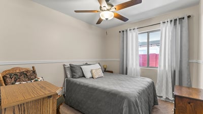 Cozy bedroom with carpet flooring, ceiling fan, and functional layout for everyday living.