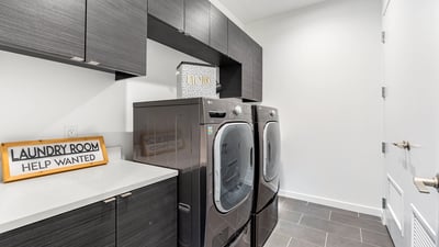Functional laundry space with full-size appliances, built-in storage, and modern finishes, adding efficiency to everyday living in Phoenix.