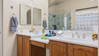 Bathroom featuring dual sinks, executive-height counters, and ample storage, designed for everyday convenience in this Phoenix property.
