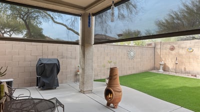 Backyard with artificial turf, covered patio, and low-maintenance design, ideal for outdoor relaxation and entertaining in Phoenix.
