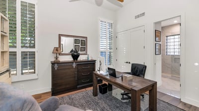 Private office with plantation shutters, natural light, and wood floors, ideal for working from home in this Phoenix property.