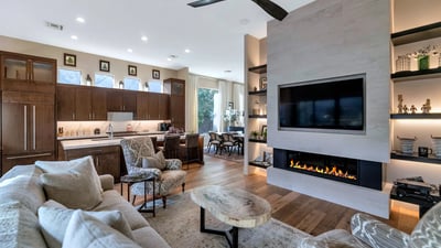 Open living area featuring a sleek fireplace, built-in shelving, and connection to the kitchen for easy entertaining in Phoenix.