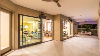Expansive covered patio with tile flooring, ceiling fans, and sliding glass doors, creating a seamless transition between indoor comfort and Scottsdale outdoor living.