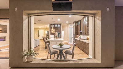 Elegant view into the modern kitchen with island seating, pendant lighting, and custom cabinetry, highlighting upscale Scottsdale interior design.