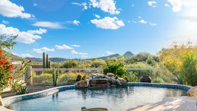 Scottsdale backyard pool overlooking scenic desert and mountain views, enhanced by mature landscaping and peaceful surroundings.