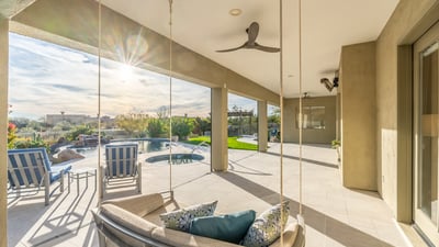 Scottsdale covered patio featuring modern hanging seating, ceiling fans, and open views to the pool and backyard.