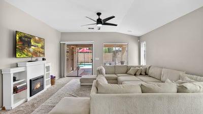 Light-filled living room with fireplace and direct access to the backyard pool area. Open design creates a welcoming space for relaxing or entertaining in this Casa Grande home.