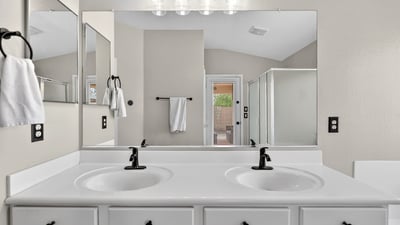 Spacious primary bathroom with dual vanities and modern fixtures. Functional layout enhances everyday convenience in Casa Grande.