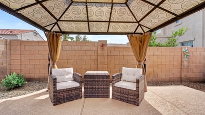 Backyard pergola with cozy seating creates a peaceful outdoor retreat. Perfect for relaxing near the pool in this Casa Grande home.