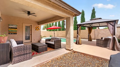 Covered patio with seating and views of the pool and pergola area. Designed for entertaining and enjoying Arizona-style outdoor living in Casa Grande.