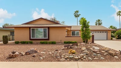 Front exterior with classic desert landscaping and mature greenery. This Sun City property highlights low-maintenance design and updated home features.