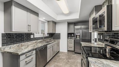 Kitchen with built-in storage, updated counters, and stainless steel appliances. This Sun City home highlights modern updates and organized space.