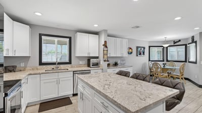 Open kitchen flowing into dining area with updated cabinetry, modern finishes, and natural light enhancing the space.