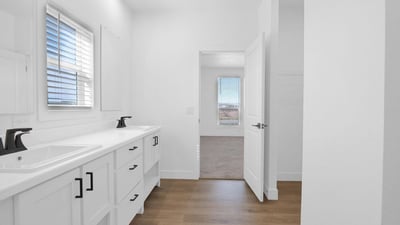 Spacious owner's bathroom offering dual vanities, modern fixtures, luxury flooring, and a bright open layout. The clean design and quality finishes add style and convenience to the primary suite.