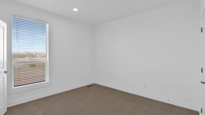 Light-filled bedroom with attractive finishes, large windows, and comfortable carpeting. Perfect for use as a guest room, family bedroom, hobby room, or home office.