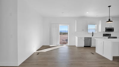 Open dining space positioned beside the kitchen and backyard access, offering abundant natural light and easy indoor-outdoor flow. Modern finishes and an open layout create an ideal setting for gatherings and family meals.