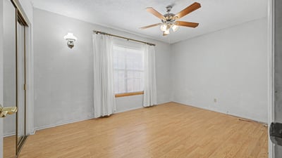 This bright secondary bedroom offers natural light, a ceiling fan, and attractive flooring. Its versatile layout makes it ideal for guests, family, remote work, or creative hobbies.