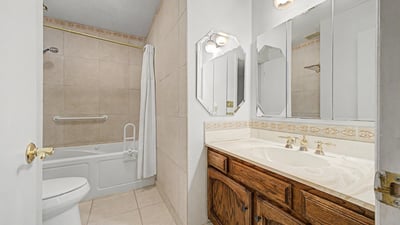 Featuring a large vanity, attractive tilework, and a tub-shower combination, this guest bathroom balances style and functionality. Ample storage and thoughtful design make daily routines convenient and comfortable.